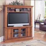 Wooden corner TV cabinet with additional upper shelf in modern rustic style a big flat TV classic area rug wood floors idea an arm chair with black stained wood side table with table lamp 1 1